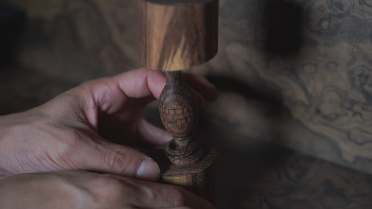 Off-Axis Ugetsubiki Ornament — the captive ring at its waist turned by hand
